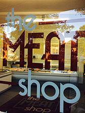 an image of window graphics saying the meat shop in red and white .produced and installed by imagine